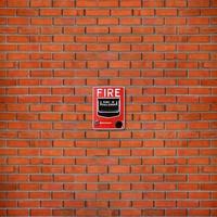 Fire alarm switch on brick wall texture background photo