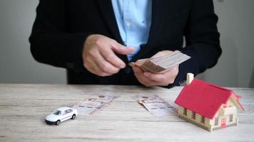 zakenman telt contant geld voor de betaling van zijn auto en huishypotheek video