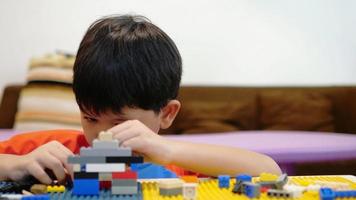 jongen speelt plastic kleurrijke speelgoedpuzzel en oefent zijn hersenen video