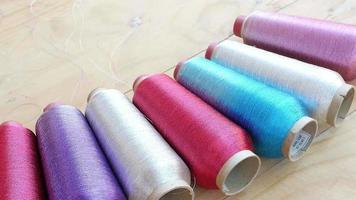 Sewing equipment or material background footage - multi color spool of threads on wooden table video