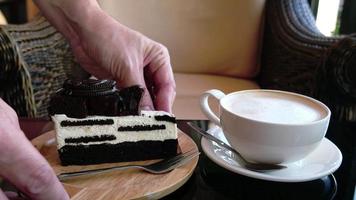 coffee and bakery people and service concept, man or waiter is serving cheesecake brownies on white wooden plate in a coffee shop - closeup at hands and white hot coffee cup on a table video