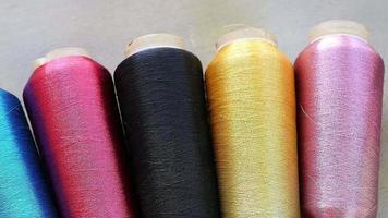 Sewing equipment or material background footage - multi color spool of threads on wooden table video