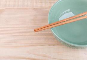 Chopsticks in asian set table on wood background photo