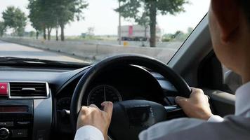 primo piano di un uomo che guida un'auto usando due mani video