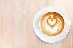 Top view latte art coffee on wood background photo