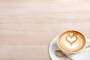 una taza de café con leche con cuchara en la mesa de madera foto