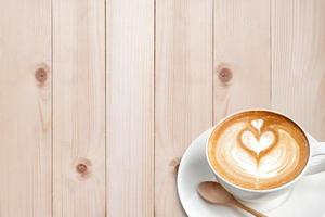 A cup of coffee latte with spoon on wood blackground photo