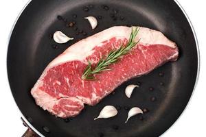 Raw red sirloin steak with rosemary, garlic , pepper photo