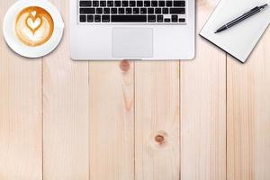 Top view laptop or notebook workspace office and latte coffee on wood table photo