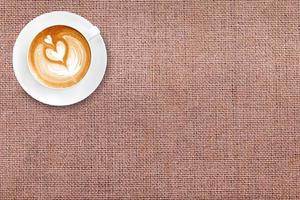 Top view latte art coffee on cotton fabric background photo