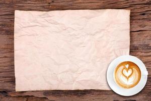 Cup of coffee and paper texture on wooden photo