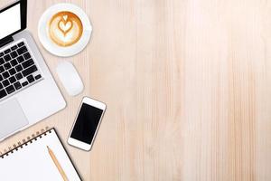 Top view laptop computer or notebook,mobile phone and cup of latte art coffee on wooden tablemobile phone,and cup of latte art coffee on wooden table photo