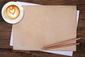 blank paper with pencil and a cup of coffee on wooden photo