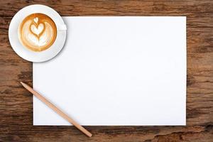 papel en blanco con lápiz y una taza de café en madera foto