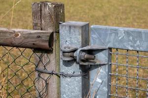 Metal hinge of gate on fence photo