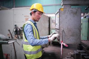 Portrait of a Professional Heavy Industry Engineer Worker Wearing Uniform, Glasses and Hard Hat in a Steel Factory. Industrial Specialist Standing in Metal Construction Facility. photo