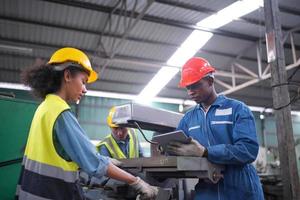 Portrait of a Professional Heavy Industry Engineer Worker Wearing Uniform, Glasses and Hard Hat in a Steel Factory. Industrial Specialist Standing in Metal Construction Facility. photo