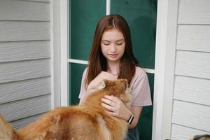 young girl in casual clothes hugging golden retriever while sitting on floor photo