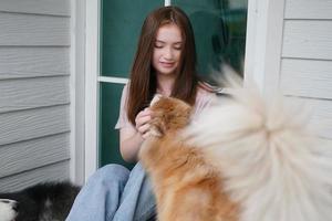 jovencita con ropa informal abrazando a un golden retriever mientras se sienta en el suelo foto