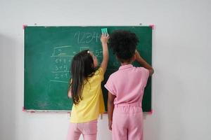 niñas felices contra la pizarra con el regreso a la escuela foto