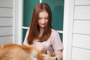 young girl in casual clothes hugging golden retriever while sitting on floor photo