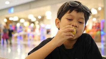 Kid with broken teeth is eating donuts happily video