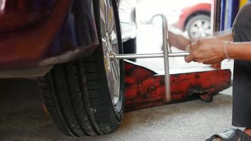 técnico fazendo manutenção do sistema de pneus de carro na garagem - conceito de manutenção do carro video