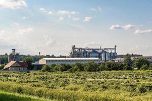 silos de plata en la planta de procesamiento y fabricación de productos agrícolas para el procesamiento, secado, limpieza y almacenamiento de productos agrícolas, harina, cereales y granos. ascensor granero. foto