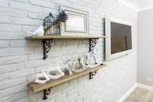 interior decoration toys. White decorative bird near cage and ceramic horses in expensive interior photo