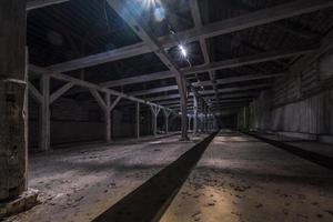 inside dark abandoned ruined wooden decaying hangar with rotting columns photo