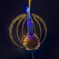 año nuevo pequeño planeta. Vista nocturna panorámica aérea esférica de 360 grados en una plaza festiva con un árbol de Navidad foto