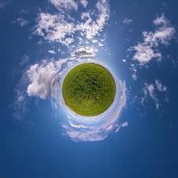 Little planet transformation of spherical panorama 360 degrees. Spherical abstract aerial view in field with awesome beautiful clouds. Curvature of space. photo