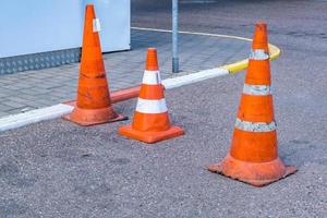 White orange traffic hazard cone on asphalt road repair photo