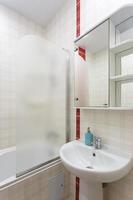 washbasin in bathroom in white style with a red stripe photo