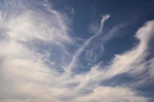 fondo de cielo azul con nubes de rayas blancas. día despejado y buen tiempo ventoso foto