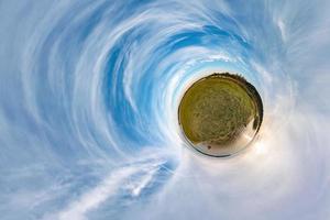 Little planet transformation of spherical panorama 360 degrees. Spherical abstract aerial view in field with awesome beautiful clouds. Curvature of space. photo