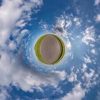 tiny planet in blue sky with sun and beautiful clouds. Transformation of spherical panorama 360 degrees. Spherical abstract aerial view. Curvature of space. photo