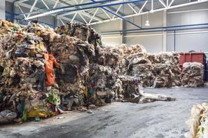 Plastic pressed bales at the modern waste hazardous processing plant. Separate garbage collection. Recycling and storage of waste for further disposal. Business for sorting and processing of waste. photo