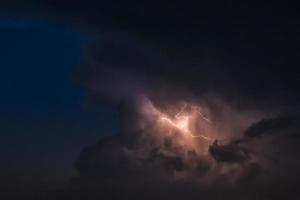 flash of lightning on a heavy cloudy background bringing thunder bolts photo