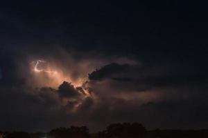 relámpago sobre un fondo nublado pesado trayendo rayos de trueno foto