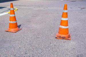 cono de peligro de tráfico naranja blanco en la reparación de carreteras de asfalto foto