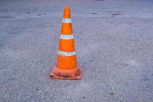 cono de peligro de tráfico naranja blanco en la reparación de carreteras de asfalto foto