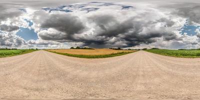 panorama hdr esférico completo sin costuras vista en ángulo de 360 grados en camino de grava entre campos con impresionantes nubes negras antes de la tormenta en proyección equirectangular, vr ar contenido de realidad virtual foto