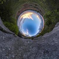 Inversion of blue little planet transformation of spherical panorama 360 degrees. Spherical abstract aerial view on road with awesome beautiful clouds. Curvature of space. photo