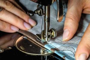 manos de mujer de costurera usando máquina de coser vintage foto
