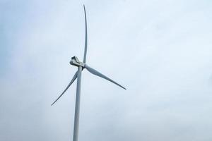 rotating blades of a windmill propeller on blue sky background. Wind power generation. Pure green energy. photo