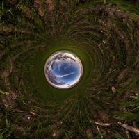 Inversion of blue tiny planet transformation of spherical panorama 360 degrees. Spherical abstract aerial view on field with awesome beautiful clouds. Curvature of space. photo