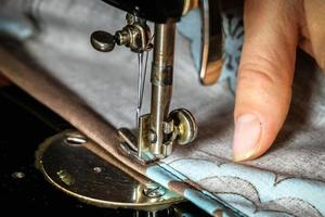 manos de mujer de costurera usando máquina de coser vintage foto