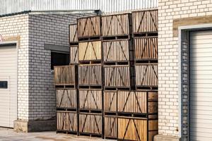 filas de cajas de madera y palets para frutas y verduras en stock de almacenamiento. almacén de producción. industria vegetal foto