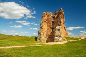 Ruins of an ancient medieval abandoned knight castle of the Grand Duchy of Lithuania, the largest state in Europe with gravel path in sunny summer day photo